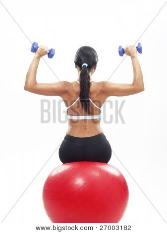 Genç kadın fitness egzersiz bir kırmızı top yapıyor.
