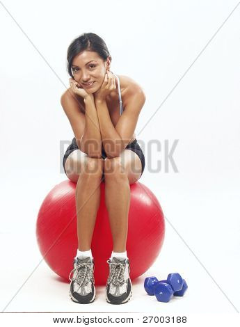 Genç kadın fitness egzersiz bir kırmızı top yapıyor.