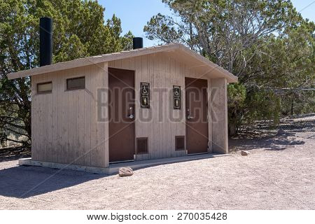 Rustic Pit Toliet Bathrooms Outdoors With Two Stalls On A Sunny Day In A Park
