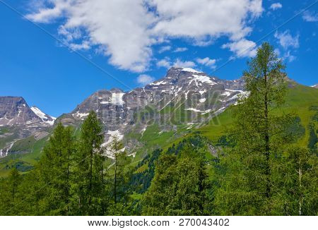 Panoramic view at Pasterze Glacier Grossglockner among austrian Alps mountains summits blue sky clouds.