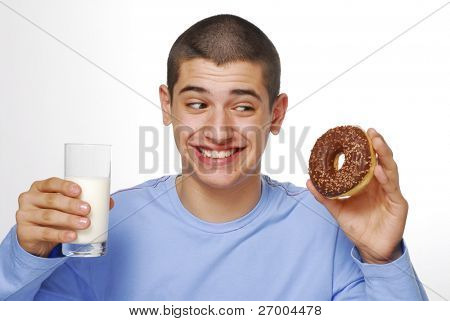 Kleine Junge holding und ein Schokoladen Donuts Essen und trinken Milch auf weißem Hintergrund.