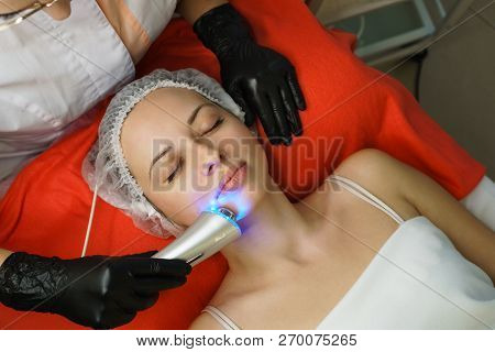 Hardware Cosmetology. Beautician Makes Ultrasonic Cleaning The Face Of The Client. Skin Pore Cleansi