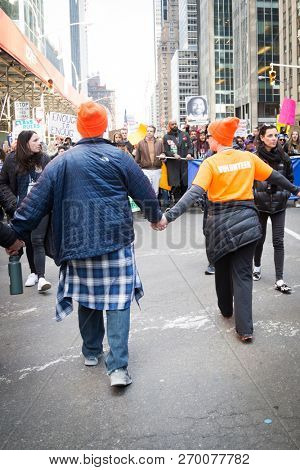 March For Our Lives: Governor Andrew Cuomo surrounded by volunteers holding hands while walking in the march on 6th Ave to end gun violence, NEW YORK MAR 24 2018.