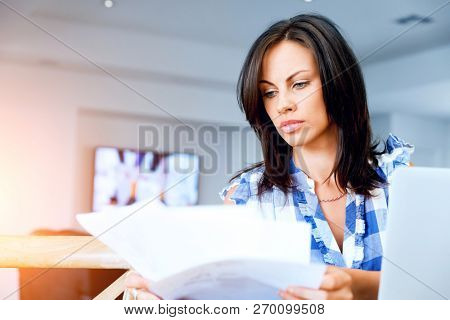 Woman with papers in their living room