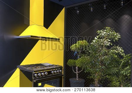 Gas Stove And Hood On The Background Black And Yellow Kitchen Interior