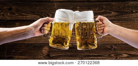 Hands Holding Mugs Of Bavarian Beer Oktoberfest.