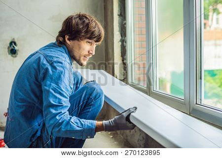 Man In A Blue Shirt Does Window Installation