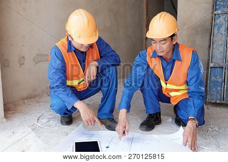 Professional Vietnamese Civil Engineer Showing Blueprint His Emplyee At Construction Site