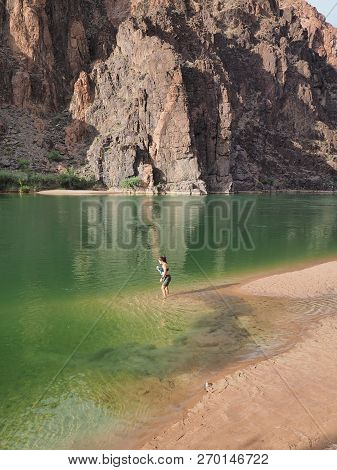 Grand Canyon National Park, Arizona 05-20-2018 Young Woman Wades In The Colorado River Guring A Back