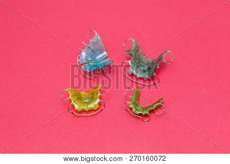 Colorful Dental Braces Or Retainers For Teeth On Pink Background, Closeup