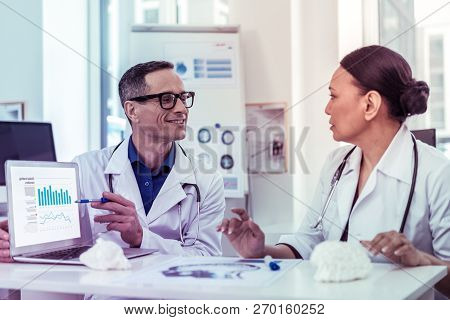 Joyful Young Man Pointing At Graph On Tablet