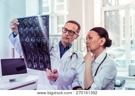 Concentrated Asian Female Listening To Her Colleague