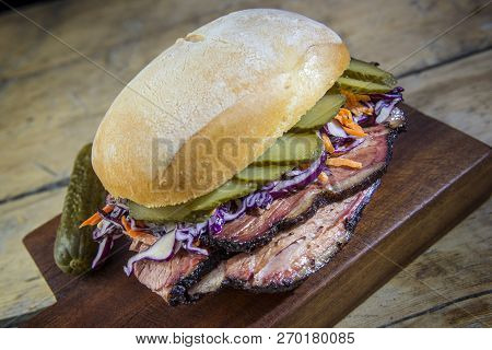 Brisket Sandwich With Cucumber And Coleslow On Cutting Board