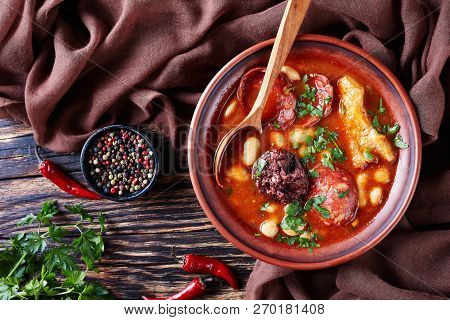 Fabada Asturiana Bean Hearty Stew In An Clay Bowl With Spoon On A Rustic Wooden Table With Brown Clo