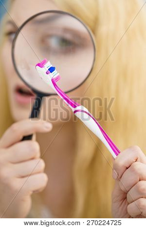 Beautiful Perfectionist Young Woman Checking Her Tooth Brush Through Manifying Loupe Glass. Hygiene,
