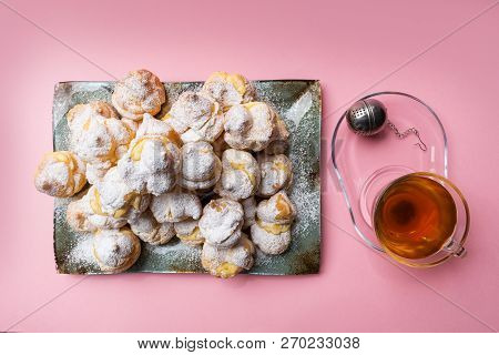 Homemade Profiteroles Served On A Plate With A Cup Of Tea On A Pink Background. Flat Lay. Stock Imag