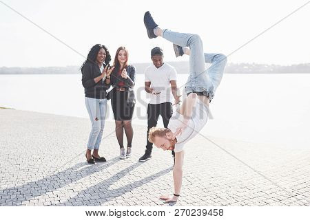 Street Artist Breakdancing Outdoors. Surprised Friends Applaud.