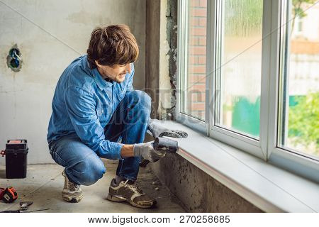 Man In A Blue Shirt Does Window Installation