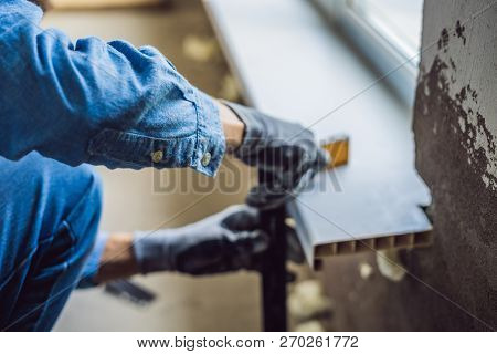 Man In A Blue Shirt Does Window Installation