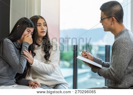 Asian Male Professional Psychologist Doctor Giving The Consult To Lesbian Lovers Patients Which Have