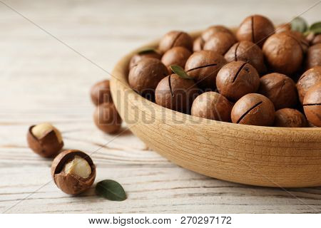 Plate With Organic Macadamia Nuts And Space For Text On Wooden Background