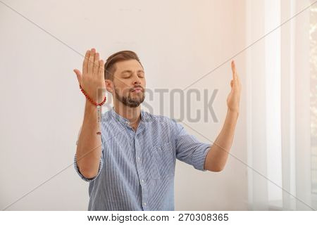 Muslim Man With Misbaha Praying In Light Room