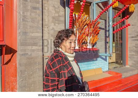 Portrait Photo Of Asian Senior Women With Tanghulu Famous Chinese Street Food On Qianmen Street.qian