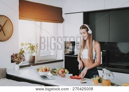 Girl Is Cooking And Listen To Music In Headphones. Healthy Lifestyle. Young And Handsome. Sport Body