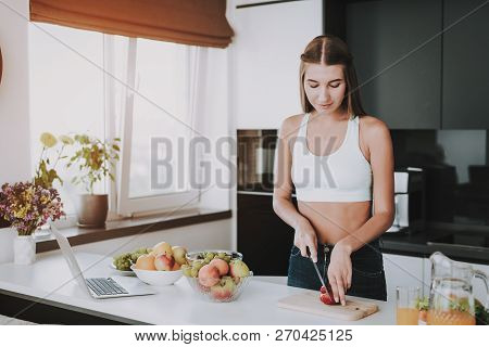 Athletic Girl Stands In Kitchen. Cooking Concept.. Healthy Lifestyle. Young And Handsome. Sport Body