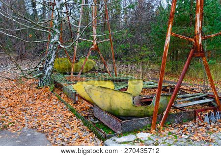 Rusted Boat Swings At Amusement Park In Abandoned Ghost Town Of Pripyat, Chernobyl Npp Alienation Zo