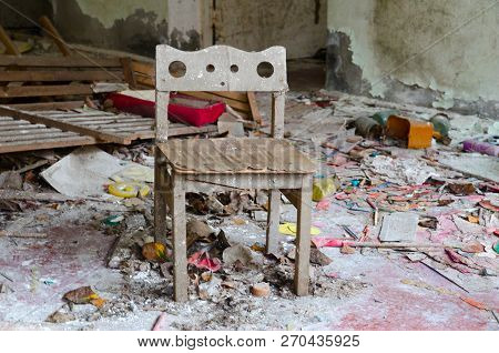 Small Wooden Chair Among Dirt And Debris In Abandoned Kindergarten, Dead City Of Pripyat, Chernobyl 