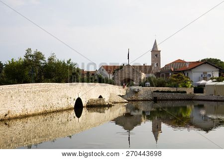 Nin, Croatia - September 6, 2012: Nin Cityscape. Nin is A Town In Croatia. A Stone Bridge Of The 16t