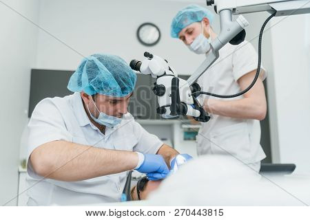 Doctor Used Microscope. Dentist Is Treating Patient In Modern Dental Office. Operation Is Carried Ou