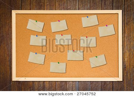bacheca di sughero con vecchia carta nota sulla parete in legno