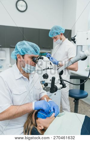 Doctor Used Microscope. Dentist Is Treating Patient In Modern Dental Office. Operation Is Carried Ou