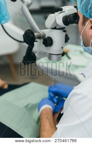 Doctor Used Microscope. Dentist Is Treating Patient In Modern Dental Office. Operation Is Carried Ou