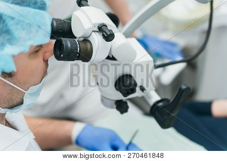 Doctor Used Microscope. Dentist Is Treating Patient In Modern Dental Office. Operation Is Carried Ou