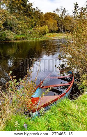 Boat And Trees With Reflection In Owenriff River