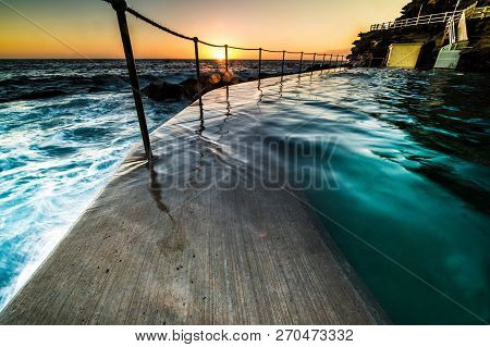Bronte Pool, Sydney At Sunrise With The Orb Of The Sun Just Appearing Over The Horizon Lighting Up T