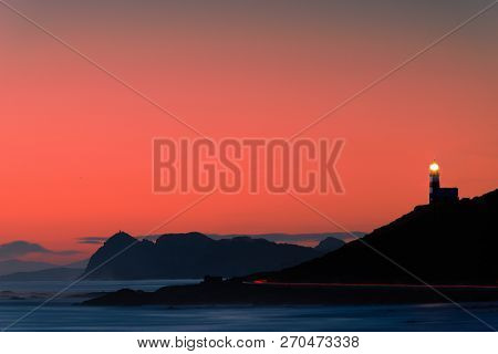 Wondeful Red Cloudy Sky At Sunset With The Lighthouse In The Background, Contrasting Wiht The Alread