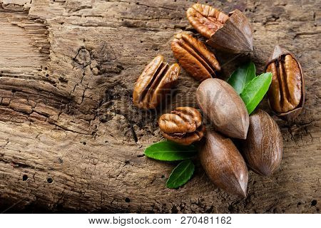 Pecan Nuts On A Brown Wooden Table Clouseup,copy Space For Your Text