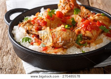 Haitian Chicken Stewed In A Spicy Tomato Sauce Served With White Rice Close-up In A Pan. Horizontal