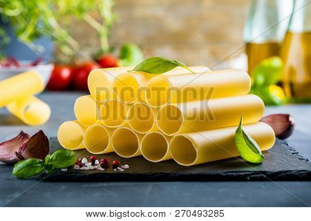 Fresh Raw Homemade Connelloni Pasta On Dark Table.