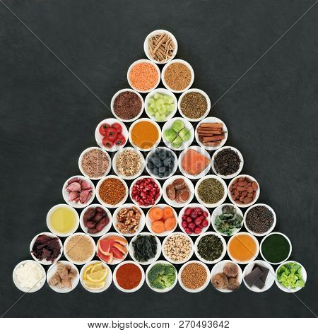 Health food to slow ageing process concept in white bowls forming a triangle shape on slate background. Super foods very high in antioxidants, anthocyanins, dietary fibre and vitamins. 