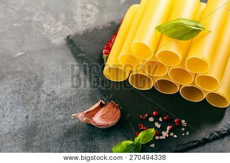 Fresh Raw Homemade Connelloni Pasta On Dark Table.