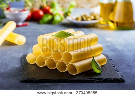 Fresh Raw Homemade Connelloni Pasta On Dark Table.