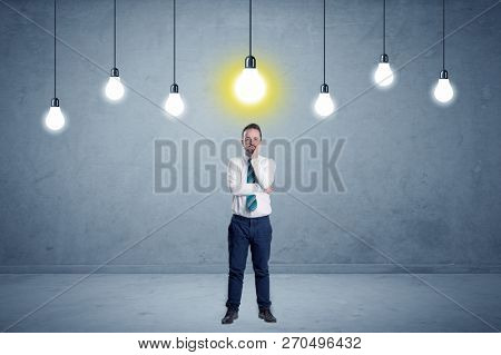 Handsome businessman in an empty space with bulbs above and uninspired face