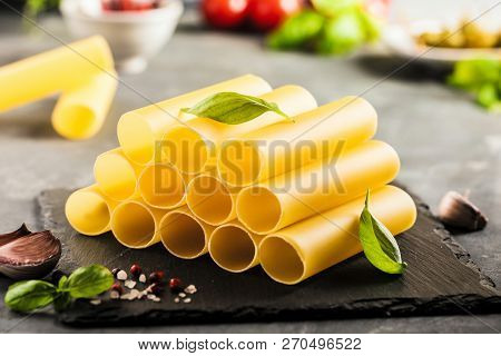 Fresh Raw Homemade Connelloni Pasta On Dark Table.