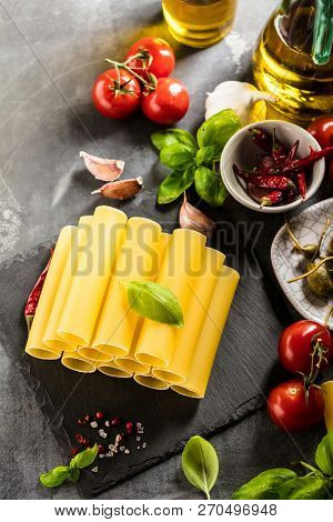 Fresh Raw Homemade Connelloni Pasta On Dark Table.