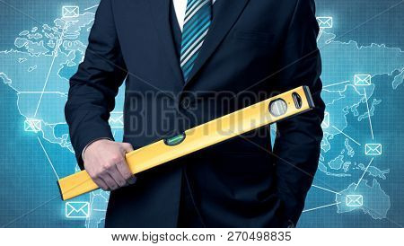 Businessman holding tool with global map graphic on the background